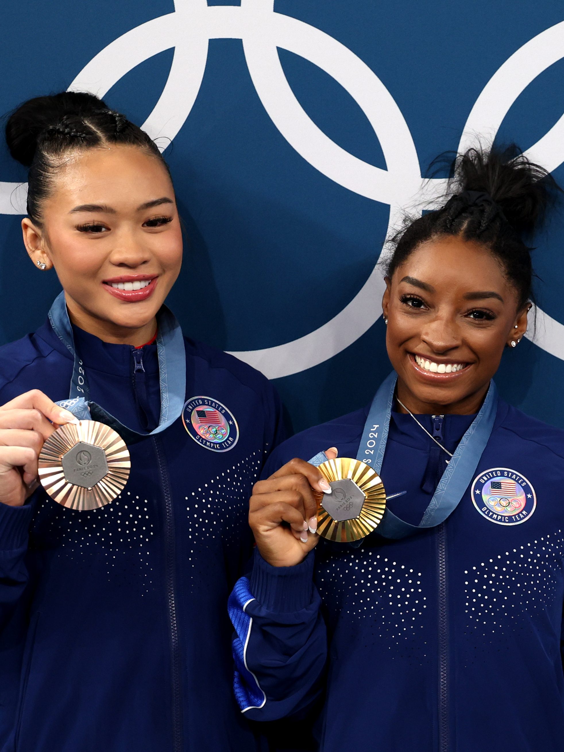 Sunisa Lee and Gold medalist Simone Biles of Team United States pose with the Olympic Rings