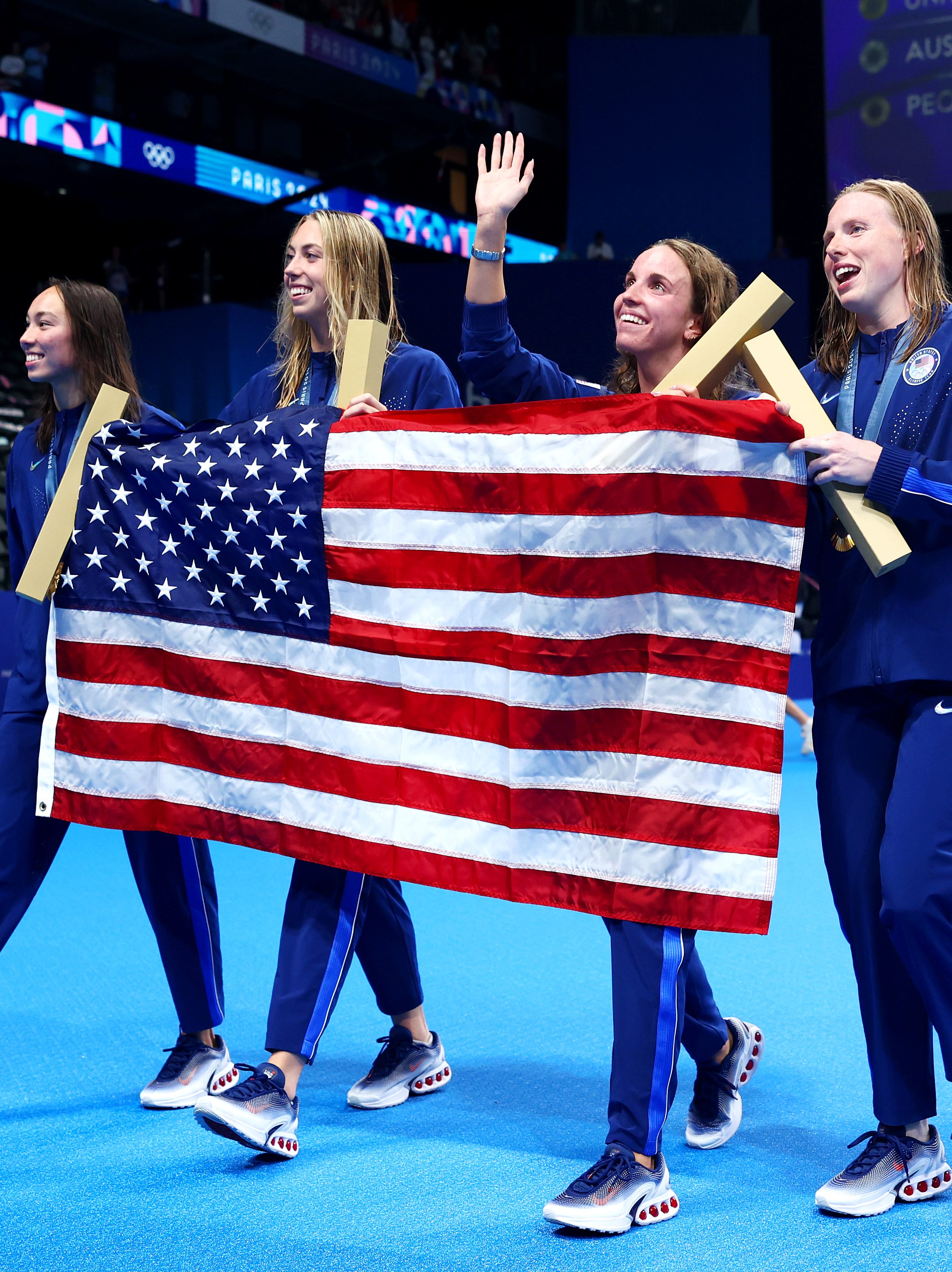 NANTERRE, FRANCE - AUGUST 04: Gold Medalists Regan Smith, Lilly King, Gretchen Walsh and Torri Huske of Team United States celebrate with the national flag of the United States following the Swimming medal ceremony after the Women’s 4x100m Medley Relay Final on day nine of the Olympic Games Paris 2024 at Paris La Defense Arena on August 04, 2024 in Nanterre, France. (Photo by Maddie Meyer/Getty Images)