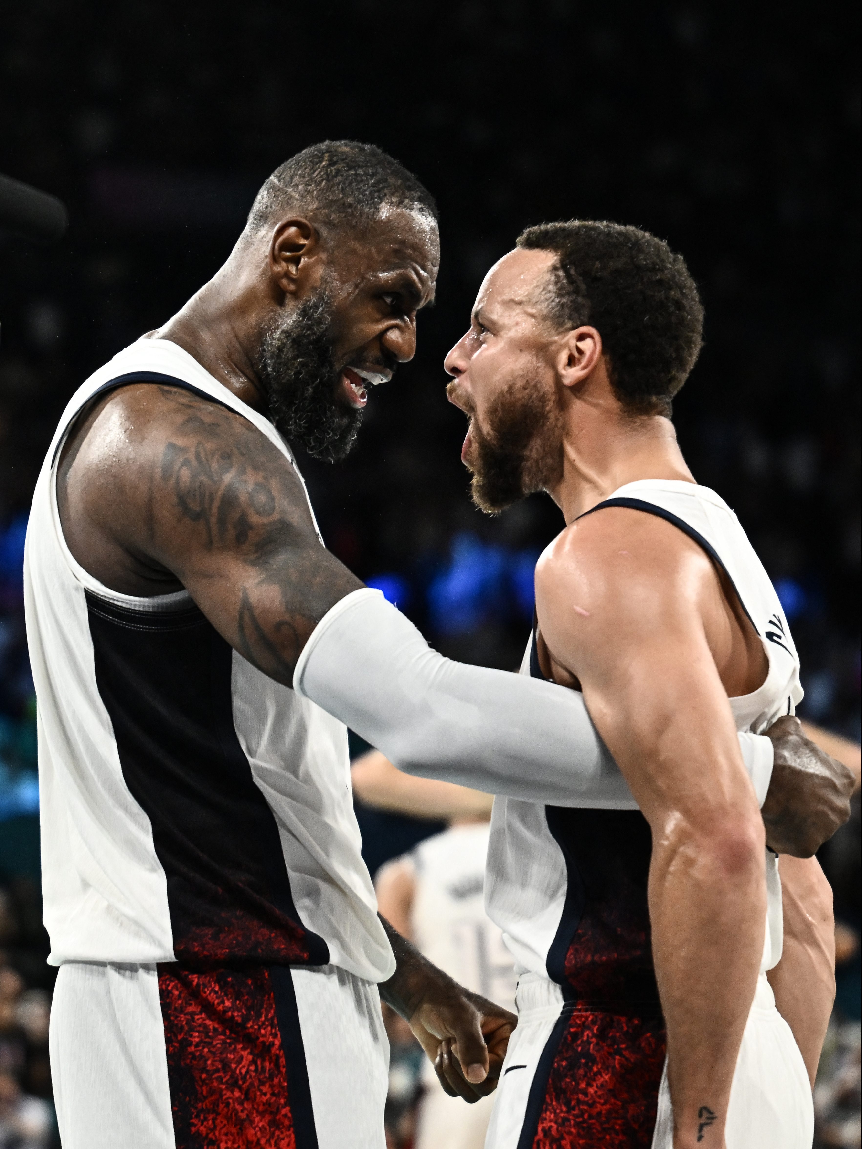 TOPSHOT - USA's #06 LeBron James (L) celebrates with USA's #04 Stephen Curry at the end of the men's semifinal basketball match between USA and Serbia during the Paris 2024 Olympic Games at the Bercy  Arena in Paris on August 8, 2024. (Photo by Aris MESSINIS / AFP) (Photo by ARIS MESSINIS/AFP via Getty Images)