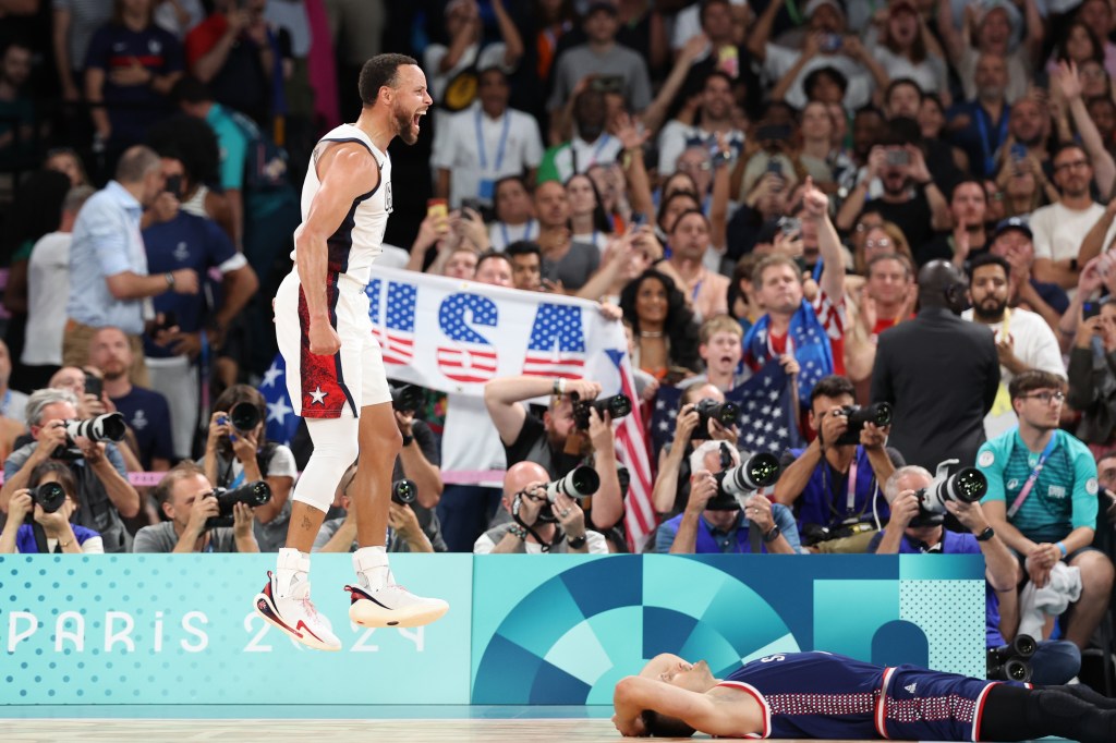 PARIS, FRANCE - AUGUST 08: Stephen Curry #4 of Team United States celebrates while Aleksa Avramovic #30 of Team Serbia reacts after Team United States' victory against Team Serbia during a Men's basketball semifinals match between Team United States and Team Serbia on day thirteen of the Olympic Games Paris 2024 at Bercy Arena on August 08, 2024 in Paris, France. (Photo by Ezra Shaw/Getty Images)