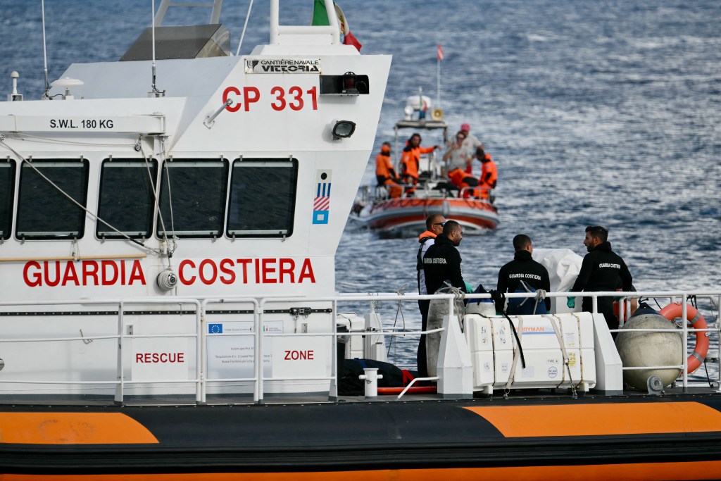 Italian Coast Guards carry a body on a rescue boat in Porticello harbor near Palermo, with a third body at the back of the boat on August 21, 2024, two days after the British-flagged luxury yacht Bayesian sank. Divers searching for six missing people following the sinking of a superyacht off Sicily in a storm have found four bodies, a source close to the search told AFP. The Bayesian, which had 22 people aboard including 10 crew, was anchored some 700 metres from port before dawn when it was struck by a waterspout. Among the six missing were UK tech entrepreneur Mike Lynch and his 18-year-old daughter Hannah, and Jonathan Bloomer, the chair of Morgan Stanley International, and his wife Judy. (Photo by Alberto PIZZOLI / AFP) (Photo by ALBERTO PIZZOLI/AFP via Getty Images)