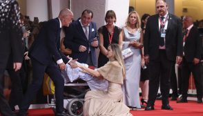 Angelina Jolie speaks to a disabled person at the 81st Venice International Film Festival