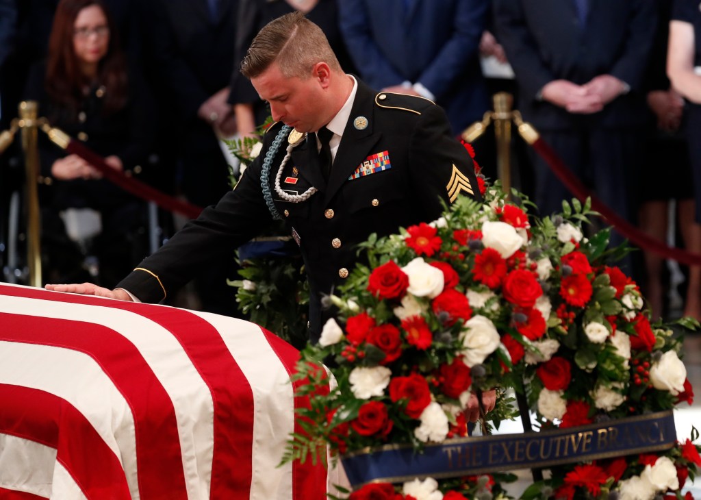 WASHINGTON, DC - AUGUST 31: Jimmy McCain, son of late U.S. Senator John McCain, touches his father's casket during ceremonies honoring the late US Senator John McCain inside the Rotunda of the U.S. Capitol, August 31, 2018 in Washington, DC. A Democrat who voted for Hillary Clinton, Farone said McCain did what was right. 'He never took the easy way out, he knew actions speak louder than words and he never tweeted about it. He just got it done,' she said. The late senator died August 25 at the age of 81 after a long battle with brain cancer. He will lie in state at the U.S. Capitol Friday, a rare honor bestowed on only 31 people in the past 166 years. Sen. McCain will be buried at his final resting place at the U.S. Naval Academy on Sunday. (Photo by Kevin Lamarque-Pool/Getty Images)