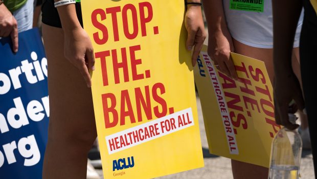 ATLANTA, GA - JULY 23: A protester holds a sign while marching and chanting through Downtown Atlanta, in opposition to Georgia's new abortion law on July 23, 2022 in Atlanta, Georgia. A federal appeals court has decided to allow a Georgia law that bans abortion after six weeks of pregnancy to go into effect.  Previously Georgia law allowed abortions up to 20 weeks of pregnancy.  (Photo by Megan Varner/Getty Images)