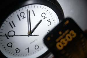 March 21, 2023, Hessen, Gießen: A smartphone shows the time "03:03"while on an analog clock it is still 02:03. On March 26, the clocks will be moved forward from 2:00 AM to 3:00 AM and daylight saving time will begin. Photo: Sebastian Christoph Gollnow/dpa (Photo by Sebastian Gollnow/picture Alliance via Getty Images)