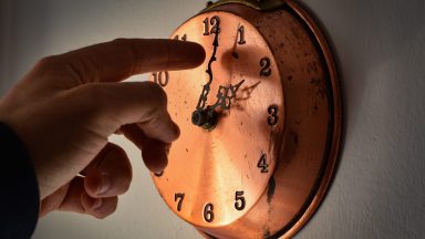 A man is seen changing the time on a clock in LAquila, Italy, March 24, 2023. On March 26 (the last Sunday of March), daylight saving time will be replaced by solar time and people around the world will move the hands of their clocks forward one hour. (Photo by Lorenzo Di Cola/NurPhoto via Getty Images)