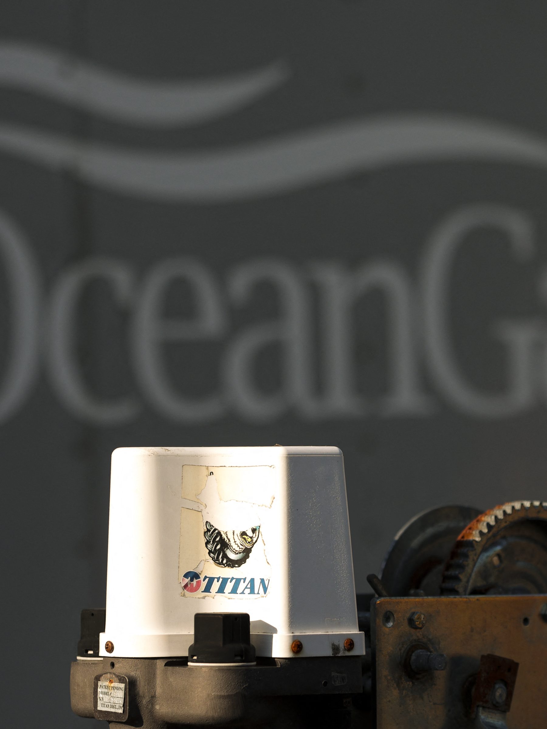 A decal on a piece of equipment which reads "Titan" is pictured near a trailer with the OceanGate logo at OceanGate Expedition's headqurters in the Port of Everett Boat Yard in Everett, Washington, on June 22, 2023. All five people aboard a submersible missing near the wreck of the Titanic died -- likely in an instant -- after their vessel suffered what the US Coast Guard said June 22, 2023 was a "catastrophic implosion" in the ocean depths. (Photo by Jason Redmond / AFP) (Photo by JASON REDMOND/AFP via Getty Images)