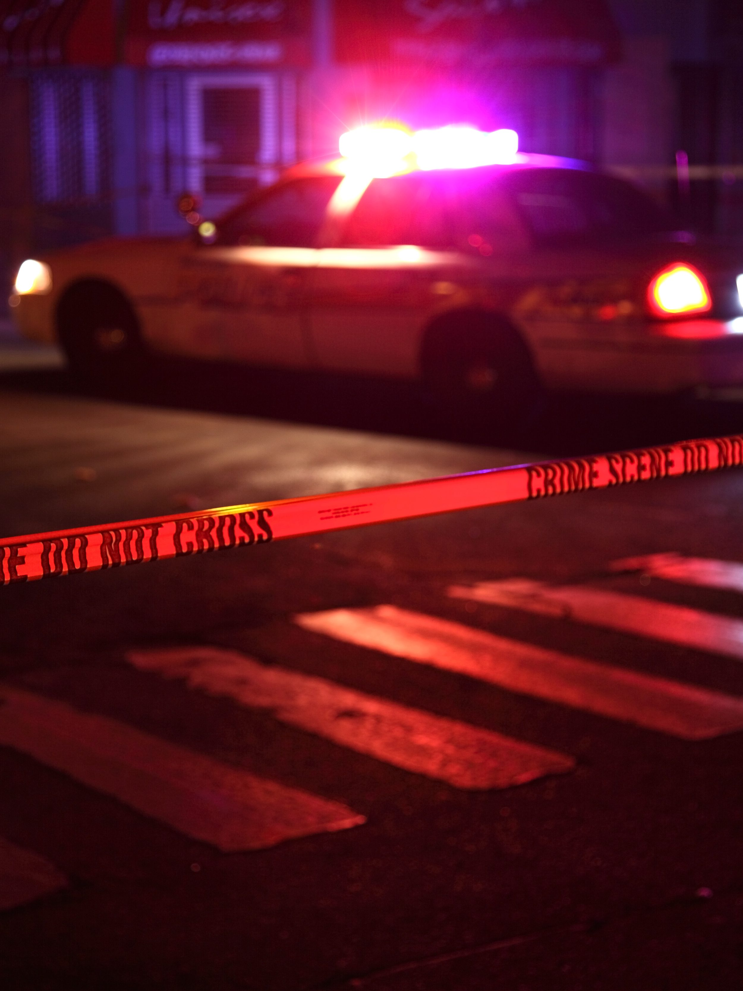Police car and crime scene tape on a city street