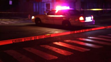 Police car and crime scene tape on a city street