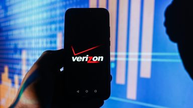 Logo Verizon jest wyświetlane na smartfonie, a w tle są notowania giełdowe. (Zdjęcie: Omar Marques/SOPA Images/LightRocket za pośrednictwem Getty Images)