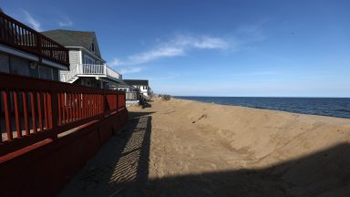 Salisbury, MA - 14 marca: Ochronne wydmy chronią dom wzdłuż plaży Salisbury. Według Toma Saaba, prezesa Salisbury Beach Citizens for Change, który nadzorował projekt, powódź zmyła z plaży Salisbury Beach około 7500 ton piasku, niszcząc połowę wartego 600 000 dolarów wysiłków na rzecz renowacji wydm, które właściciele nieruchomości podjęli w celu ochrony plaży. (Zdjęcie: Barry Chin/The Boston Globe za pośrednictwem Getty Images)