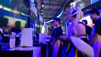 A cosplayer is playing games at the PlayStation game booth during the Chinajoy games fair in Shanghai, China, on July 26, 2024. (Photo by Ying Tang/NurPhoto via Getty Images)