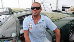 Chad McQueen poses while sitting on a 1966 Porsche 906 i