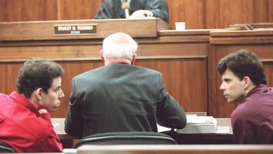   Erik (L) and Lyle (R) Menendez converse in the courtroom during a hearing in Los Angeles, in this 02 February 1995 file picture. They are accused of murdering their parents in 1989. (Photo credit should read KIM KULISH/AFP via Getty Images)