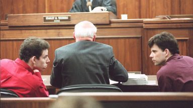   Erik (L) and Lyle (R) Menendez converse in the courtroom during a hearing in Los Angeles, in this 02 February 1995 file picture. They are accused of murdering their parents in 1989. (Photo credit should read KIM KULISH/AFP via Getty Images)