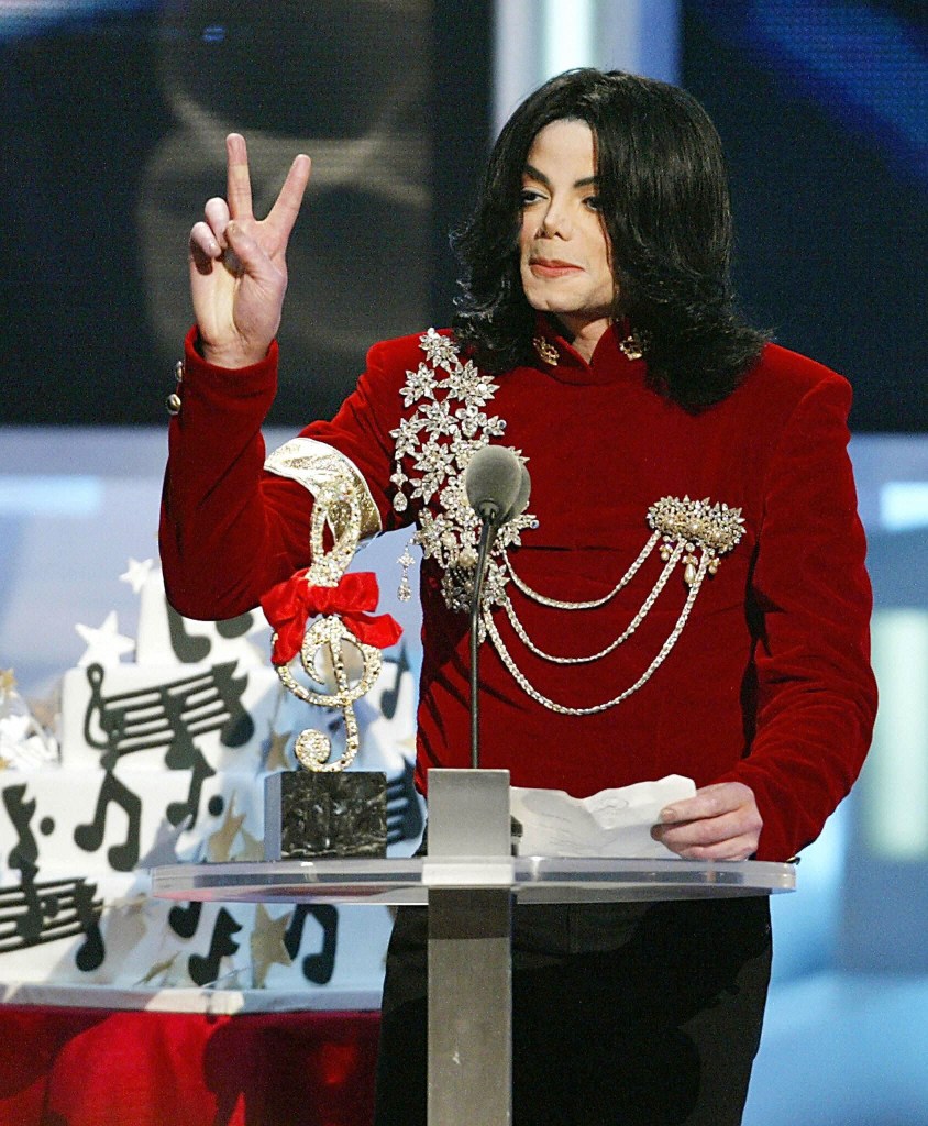 NEW YORK, UNITED STATES: US singer Michael Jackson makes a peace sign at the MTV Video Music Awards 29 August, 2002 in New York after receiving the Performer of the Millennium Award. Jackson, who is due to appear in court 16 January 2003 on child sex abuse charges, earned the title "King of Pop" with the best-selling album ever -- but his star has waned considerably in the two decades since then. Jackson, is to be arraigned on seven counts that include lewd acts against a 14-year-old boy. He has to declare whether he is innocent or guilty after Santa Barbara prosecutors filed the charges against him on 18 December. AFP PHOTO/TIMOTHY A. CLARY (Photo credit should read TIMOTHY A. CLARY/AFP via Getty Images)