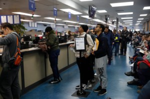 Elias Dubaie (centro de izquierda a derecha) de San Francisco y Kahlai Pratt de San Francisco observan un letrero mientras esperan en la fila para solicitar la Real ID en el DMV en Fell Street el viernes 24 de enero de 2020 en San Francisco, California. (Foto de Lea Suzuki/The San Francisco Chronicle vía Getty Images)