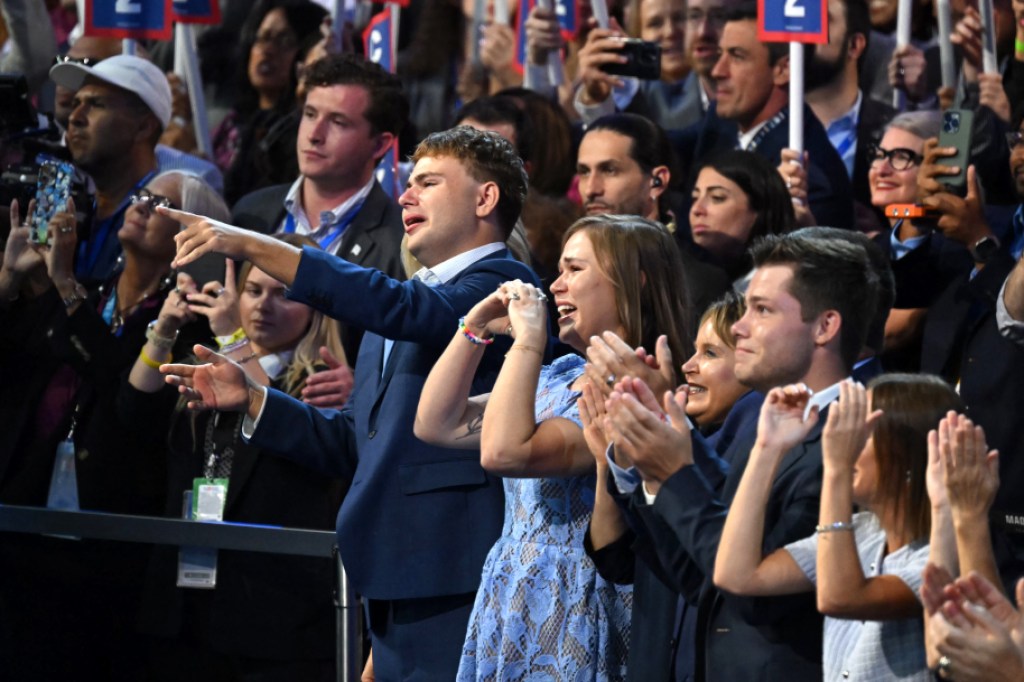 TOPSHOT - El hijo del gobernador de Minnesota y candidato demócrata a la vicepresidencia de 2024, Tim Walz, Gus (izq.), y su hija Hope (segunda izq.), reaccionan mientras habla en el tercer día de la Convención Nacional Demócrata (DNC) en el United Center en Chicago, Illinois, el 21 de agosto de 2024. La vicepresidenta Kamala Harris aceptará formalmente la nominación del partido a la presidencia en el Comité Nacional Demócrata que se celebrará del 19 al 22 de agosto en Chicago. (Foto de ANDREW CABALLERO-REYNOLDS/AFP) (Foto de ANDREW CABALLERO-REYNOLDS/AFP vía Getty Images)