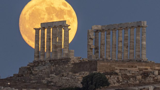 The Full Buck Moon rises behind the ancient Greek Temple of Poseidon on Cape Sounion in Greece on July 20, 2024 (Photo by Nicolas Economou/NurPhoto via Getty Images)