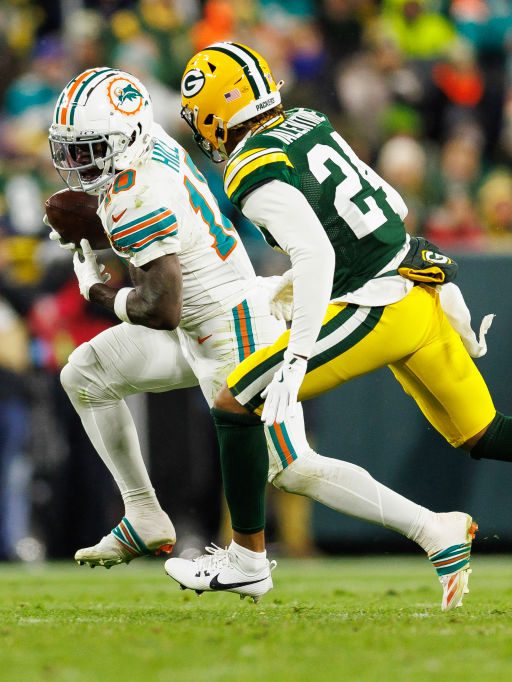 GREEN BAY, WISCONSIN - NOVEMBER 28: Wide receiver Tyreek Hill #10 of the Miami Dolphins completes a catch against cornerback Carrington Valentine #24 of the Green Bay Packers during an NFL football game, at Lambeau Field on November 28, 2024 in Green Bay, Wisconsin. (Photo by Brooke Sutton/Getty Images)