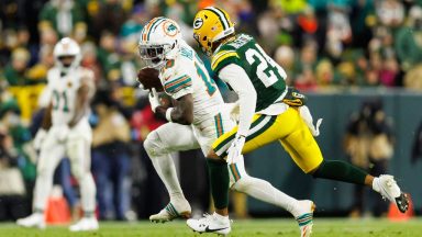 GREEN BAY, WISCONSIN - NOVEMBER 28: Wide receiver Tyreek Hill #10 of the Miami Dolphins completes a catch against cornerback Carrington Valentine #24 of the Green Bay Packers during an NFL football game, at Lambeau Field on November 28, 2024 in Green Bay, Wisconsin. (Photo by Brooke Sutton/Getty Images)