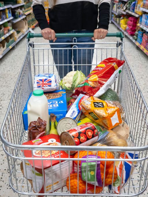 CARDIFF, WALES - MAY 22: A woman with a shopping trolley full of groceries in a supermarket aisle on May 22, 2022 in Cardiff, Wales. Last week, the UK Office for National Statistics reported an 6% average increase of food and drink prices year on year, but some staples, such as milk and pasta, had risen by more than 10%. (Photo by Matthew Horwood/Getty Images)