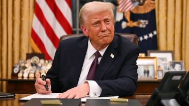 US President Donald Trump signs executive orders in the Oval Office of the White House in Washington, DC, on January 20, 2025. (Photo by Jim WATSON / AFP)