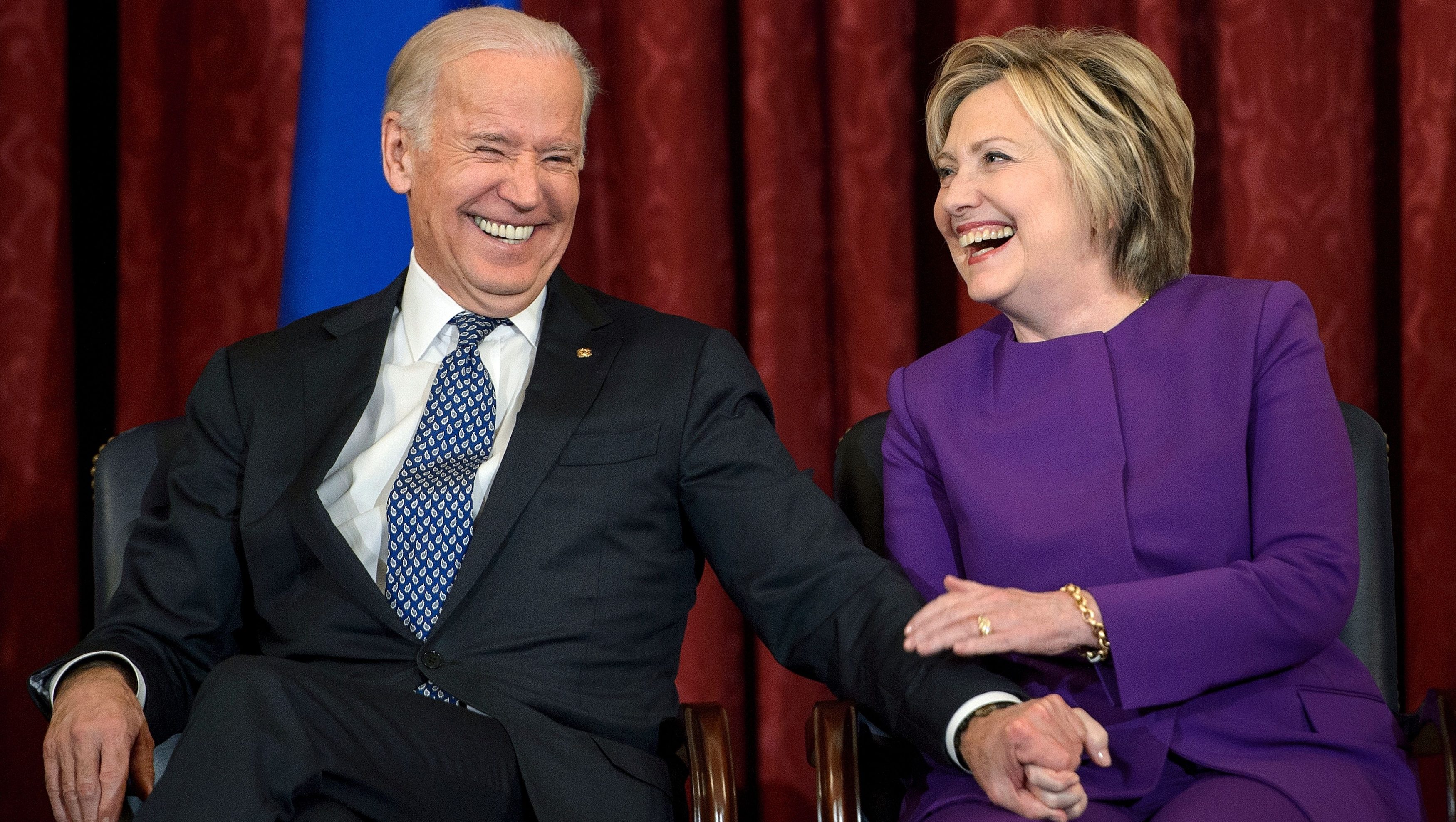 US Vice President Joe R. Biden (L) and former Secretary of State Hillary Clinton laugh during a portrait unveiling for outgoing Senate Minority Leader Senator Harry Reid (D-NV) on Capitol Hill December 8, 2016 in Washington, DC. / AFP / Brendan Smialowski        (Photo credit should read BRENDAN SMIALOWSKI/AFP via Getty Images)