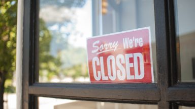 Sorry, We're Closed Sign in a small town main street  storefront window.