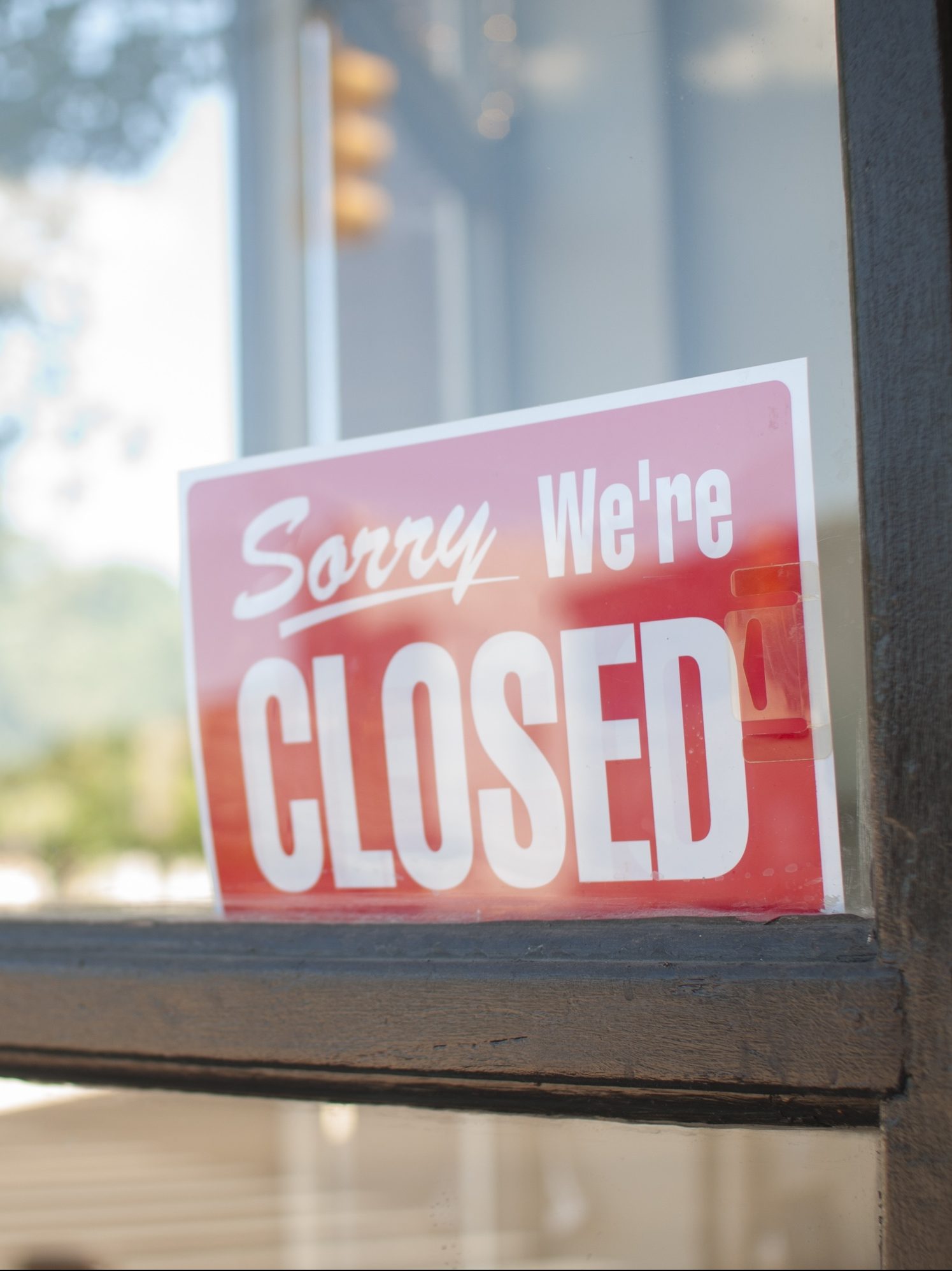 Sorry, We're Closed Sign in a small town main street  storefront window.