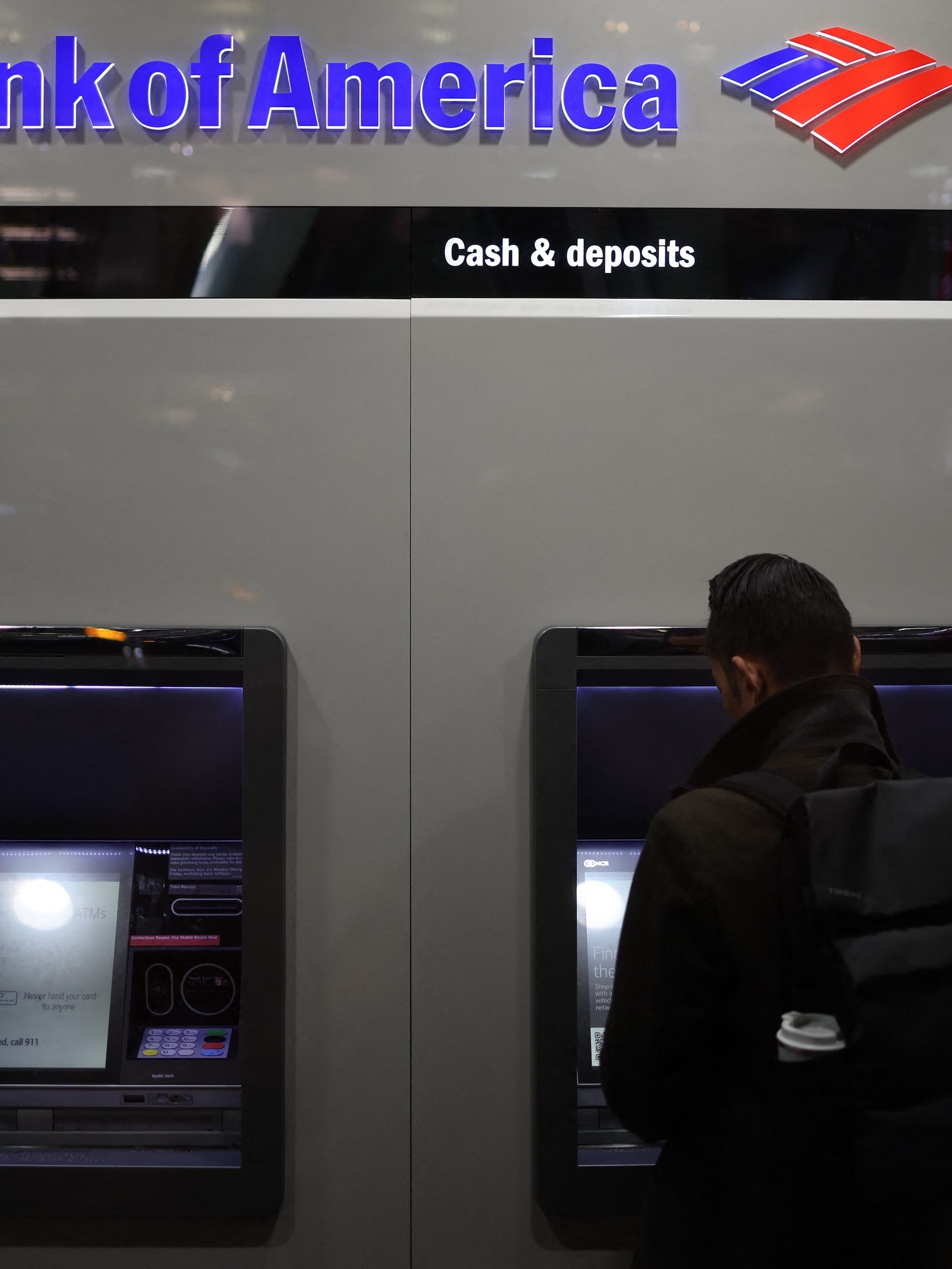 A person uses an ATM at a Bank of America in New York City on November 19, 2024. (Photo by CHARLY TRIBALLEAU / AFP)