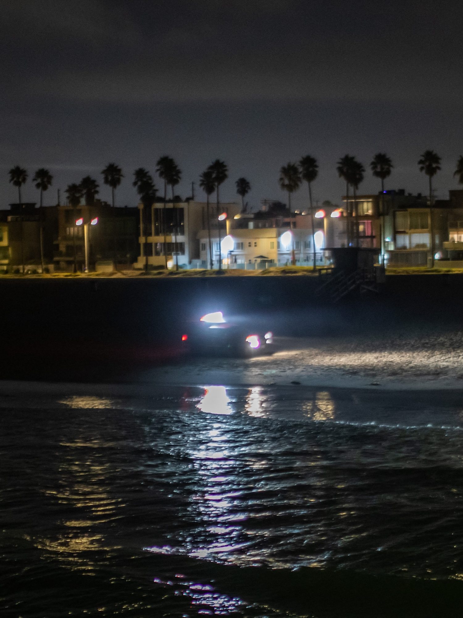 A LA County Lifeguard truck patrols Venice beach pier amid a tsunami warning in Los Angeles, California on July 30, 2025. Tsunamis hit parts of Russia's Far East and Japan on July 30 after a huge magnitude 8.8 earthquake, with warnings in place around the Pacific of waves of over three metres (10 feet) in places. (Photo by Apu GOMES / AFP)