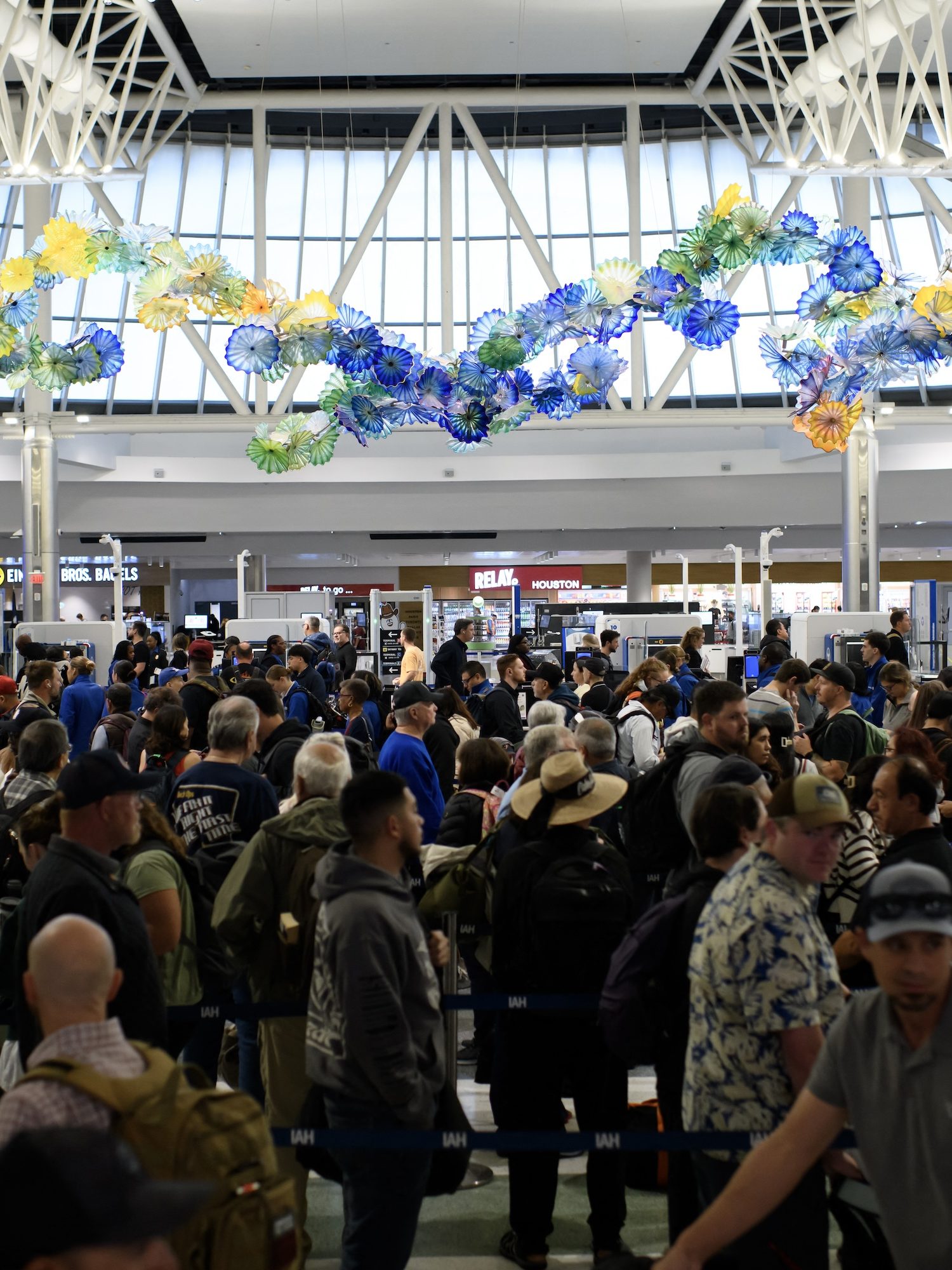 People wait in a security checkpoint line at George Bush Intercontinental Airport in Houston, Texas, on November 4, 2025. With the federal government shutdown entering its second month, lines at airports are expected to grow amid increased absenteeism among security and safety staff at some of the country's busiest hubs. (Photo by Mark Felix / AFP)