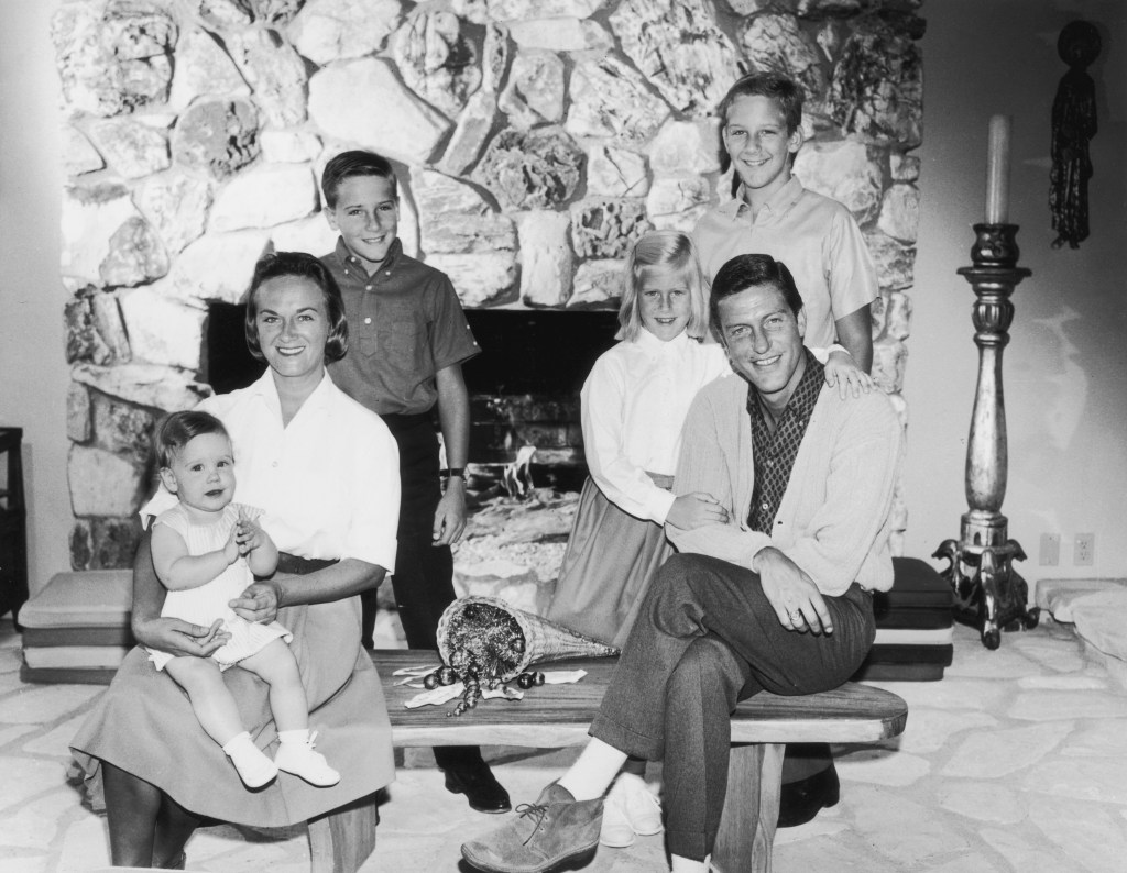 circa 1965: Portrait of American actor and comedian Dick Van Dyke with his wife, Margie Willet, posing in front of a fire place with their four children: Barry, Carrie, Chris, and Stacey. Van Dyke and Willet are sitting on a coffee table while their children stand behind them. (Photo by Hulton Archive/Getty Images)